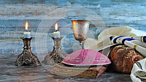 A traditional Jewish symbol of Shabbat Shalom on Saturday religious holiday, with challah bread, wine candles on a table