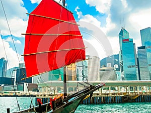 Traditional junk sailboat with red sails in the Victoria harbor, Hong Kong