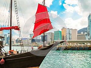 Traditional junk sailboat with red sails in the Victoria harbor, Hong Kong