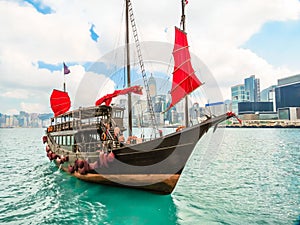 Traditional junk sailboat with red sails in the Victoria harbor, Hong Kong