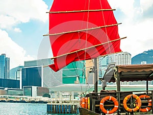 Traditional junk sailboat with red sails in the Victoria harbor, Hong Kong