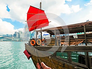 Traditional junk sailboat with red sails in the Victoria harbor, Hong Kong