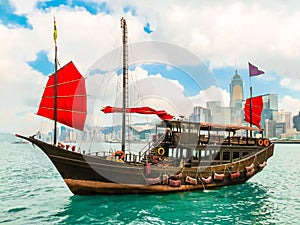 Traditional junk sailboat with red sails in the Victoria harbor, Hong Kong