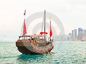 Traditional junk sailboat with red sails in the Victoria harbor, Hong Kong