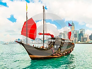 Traditional junk sailboat with red sails in the Victoria harbor, Hong Kong