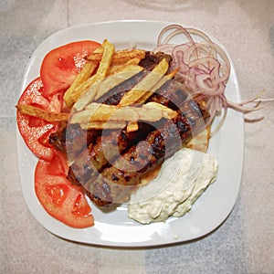 Traditional Kebab plate, with meat steaks, fries tomato and tzatziki