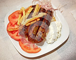 Traditional Kebab plate, with meat steaks, fries tomato and tzatziki
