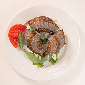 Traditional kebbe and pita bread on big round plate in lebanese restaurant