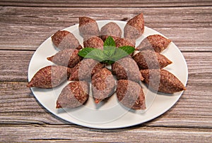 Traditional kebbe and pita bread on big round plate in lebanese restaurant