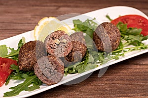 Traditional kebbe and pita bread on big round plate in lebanese restaurant