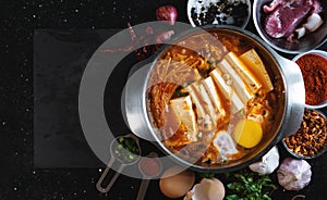 Traditional Korea food, Kimchi Jjigae soup with soft tofu and egg, surround with fresh ingredient photo