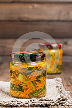 Traditional Korean snack of kimchi cucumbers in two glass jars: cucumbers marinated with carrots, hot pepper and garlic.