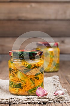 Traditional Korean snack of kimchi cucumbers in two glass jars: cucumbers marinated with carrots, hot pepper and garlic.