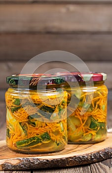 Traditional Korean snack of kimchi cucumbers in two glass jars: cucumbers marinated with carrots, hot pepper and garlic.