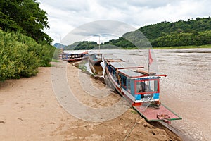 Traditional laotian boats on the bank of Mekong River, photo