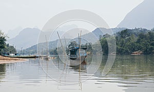 Traditional Laotian wooden slow boat on Nam Ou river near Nong Khiaw village, Laos