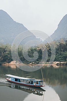 Traditional Laotian wooden slow boat on Nam Ou river near Nong Khiaw village, Laos