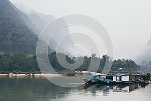 Traditional Laotian wooden slow boat on Nam Ou river near Nong Khiaw village, Laos