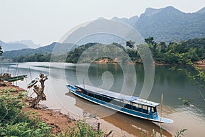 Traditional Laotian wooden slow boat on Nam Ou river near Nong Khiaw village, Laos