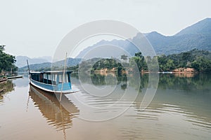 Traditional Laotian wooden slow boat on Nam Ou river near Nong Khiaw village, Laos