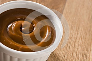 Traditional Latin American dulce de leche or manjar on wooden background.