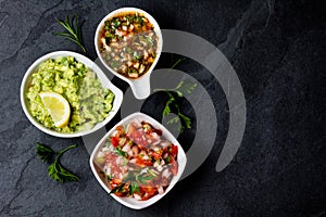 Traditional Latin American sauces Guacamole, Salsa, chili Pebre, slate background photo