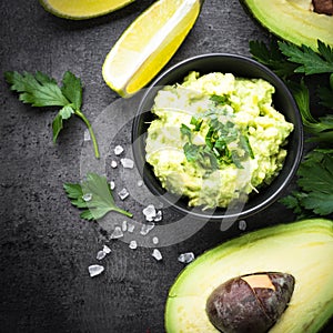 Traditional latinamerican mexican sauce guacamole on black.