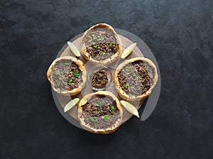 Traditional Lebanese meat pies on a black table.