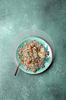 Traditional Lebanese salad tabouli tabule with quinoa, herbs, tomatoes, mint and lemon photo