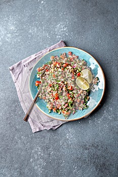 Traditional Lebanese salad tabouli tabule with quinoa, herbs, tomatoes, mint and lemon photo