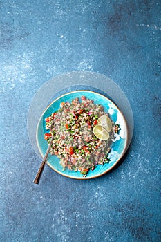 Traditional Lebanese salad tabouli tabule with quinoa, herbs, tomatoes, mint and lemon photo