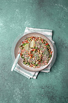 Traditional Lebanese salad tabouli tabule with quinoa, herbs, tomatoes, mint and lemon photo