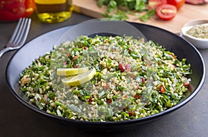 Traditional Lebanese salad tabouli tabule with quinoa, herbs, tomatoes, mint and lemon photo