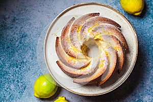 Traditional lemon cake with powdered sugar and zest, dark blue background, top view