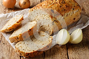 Traditional loaf of onion bread sliced close-up on parchment. Horizontal