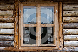 Traditional log house insulated with moss, pine wood  window