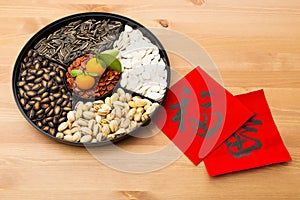 Traditional Lunar new year snack tray and chinese calligraphy, m