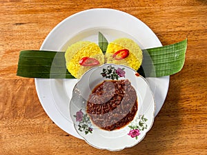 Traditional Malay food known as Pulut kuning with Sambal Tumis Ikan Bilis or Anchovies