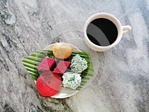 Traditional Malaysian dessert or kuih-muih served with coffee on the table.