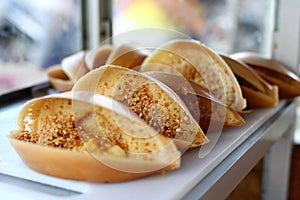 Traditional Malaysian street food apam balik - thick soft pancake with peanuts, bananas, peanut butter and sweet corn.