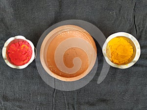 Traditional Man Made Item Sand Saucer or Bowl, Kumkum and Turmeric Powder with Steel Cup isolated on black background