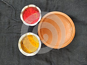 Traditional Man Made Item Sand Saucer or Bowl, Kumkum and Turmeric Powder with Steel Cup isolated on black background