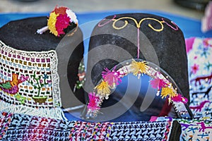 Traditional man`s hat and weavings laid out on the local sunday market of Tarabuco, Bolivia