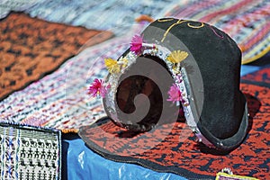 Traditional man`s hat and weavings laid out on the local sunday market of Tarabuco, Bolivia