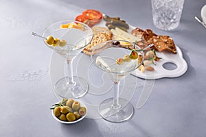 Traditional martini cocktail with olive garnish and charcuterie board