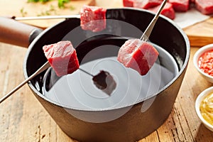 Traditional meat fondue with diced raw beef