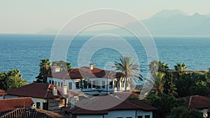 Traditional mediterranean house on the coast by the sea against the mountains view. Kaleici, Antalya, Turkey