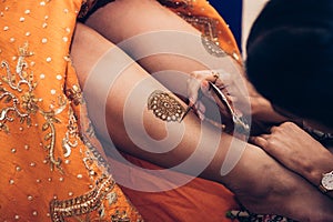 Traditional Mehndi henna pattern on female leg. Close-up photo.