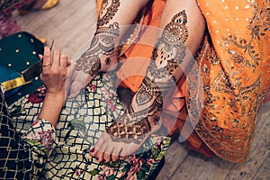 Traditional Mehndi henna pattern on female leg. Close-up photo.