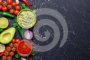 Traditional Mexican Latin American Salsa sauce and Guacamole and ingredients on black stone table. Top view copy space